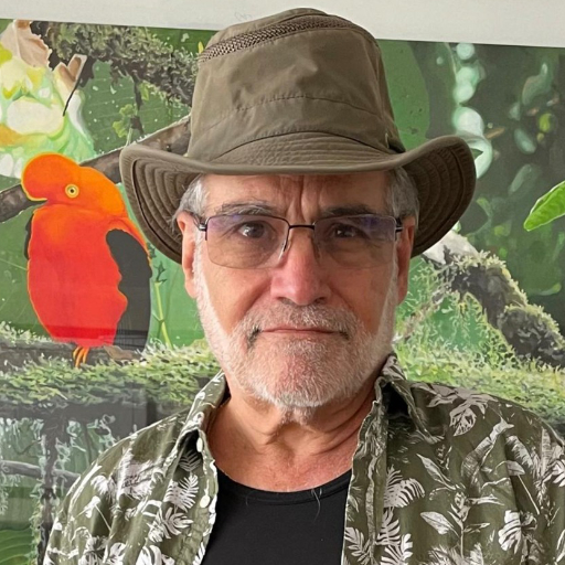 Paul Greenfield poses in front of a mural with an Andean Cock-of-the-Rock.